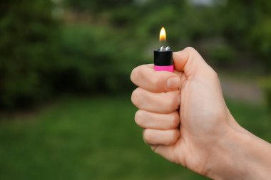 Dışarıda yanan alevi olan çakmağı tutan adam, yakın plan. Metin için boşluk