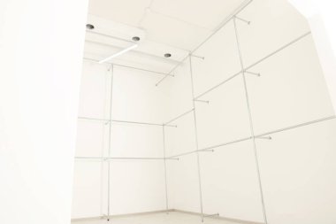 Boş ofis odasındaki beyaz duvarların yanındaki metal borular. İç tasarım