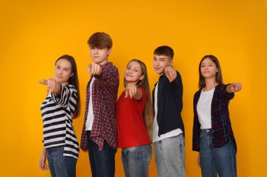 Turuncu arka planda bir grup mutlu genç.