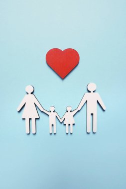 Açık mavi arka planda aile ve kalp figürleri, üst manzara. Sigorta konsepti