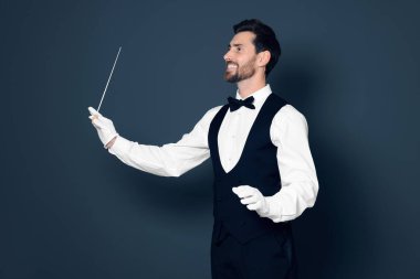 Gri arka planda batonu olan mutlu profesyonel şef