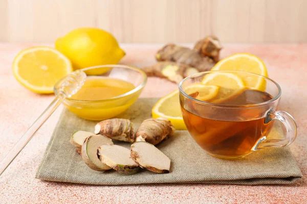 Tea, honey, lemon and ginger on beige textured table