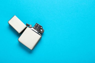 Açık mavi arka planda gri metalik çakmak, üst manzara. Metin için boşluk