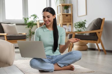 Genç bir kadının evdeki bilgisayarında görüntülü arama var.