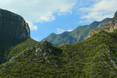 Açık havada mavi gökyüzünün altında yüksek dağları olan resim gibi bir manzara.