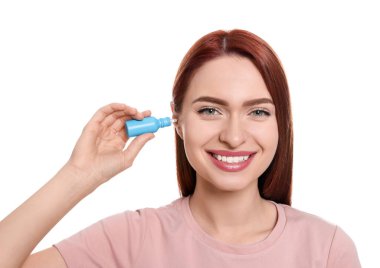 Beyaz arkaplanda kulak damlası kullanan kadın