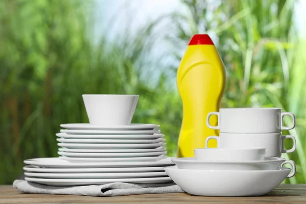背景がぼやけている白いテーブルの上にきれいな食器と洗剤のセット — ストック写真