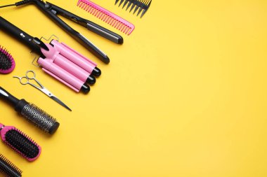 Turuncu arka planda profesyonel kuaför araçlarının düz konumu, metin için boşluk