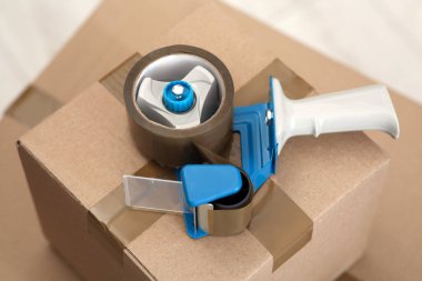 Kapalı alandaki karton kutunun üzerine yapıştırıcı bant yapıştırıcı.