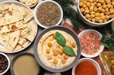 Lezzetli kremalı humus, nohut ve ahşap masa üzerinde farklı malzemeler, düz yatıyordu.