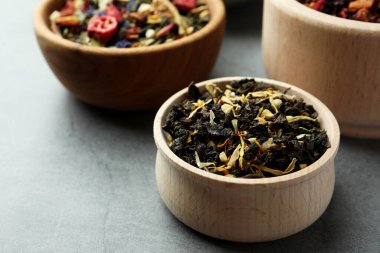 Gri masada farklı bitkisel çaylarla dolu kaseler.