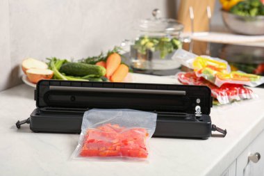 Süpürge ambalajı için mühür. Kırmızı biber ve plastik poşet. Beyaz masa içinde.