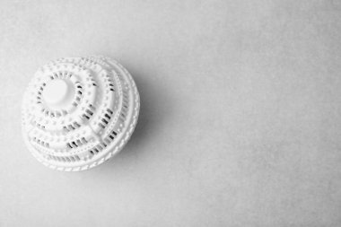 Çamaşır makinesi topu açık gri masada, üst tarafta. Metin için boşluk