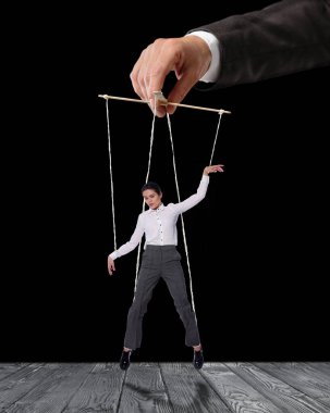 Kukla gösterisinde insan ilişkileri gösterildi. Siyah arkaplanda yönetici veya yönetmen tarafından manipüle edilen işçiler