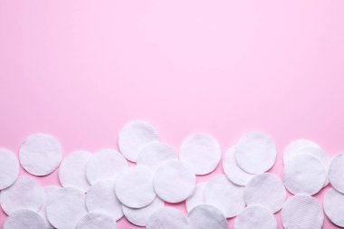 Pembe arka planda yumuşak, temiz pamuk pedleri, düz yatış. Metin için boşluk