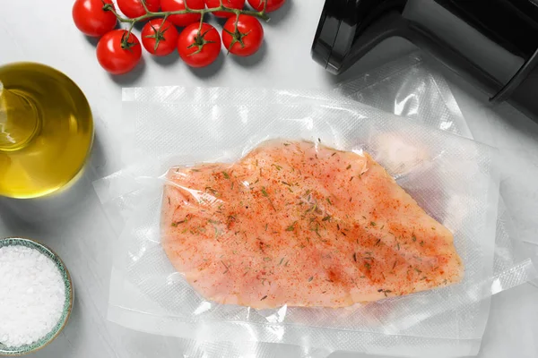 Vacuum packing with meat on white table, flat lay. Sous vide cooking