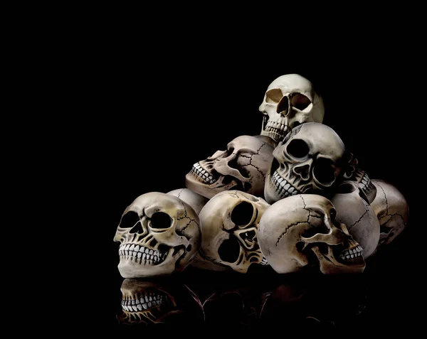 Pile of scary human skulls on black background, space for text