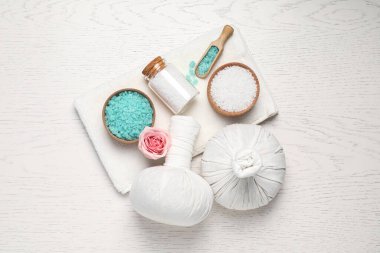 Bitkisel poşetlerin ve spa ürünlerinin düz kompozisyonu beyaz ahşap masa üzerineydi.