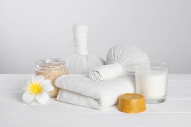 Beyaz ahşap masa üzerinde bakım ürünleri ile spa kompozisyonu