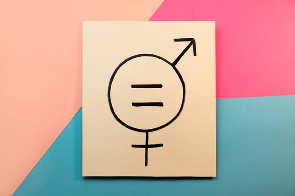 Card with equal sign and gender symbols on color background, top view