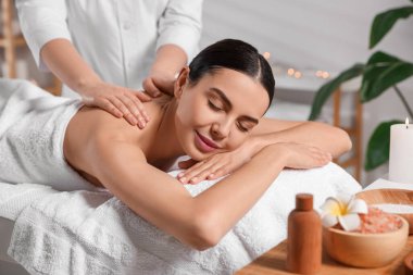 Beautiful woman receiving back massage in beauty salon, closeup clipart