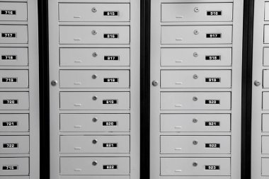 Kapalı metal posta kutuları, içinde anahtar delikleri ve seri numaraları var.