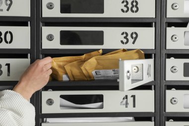 Posta kutusundan zarfı alan kadın, yakın plan.