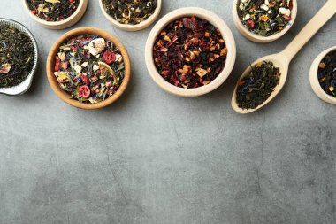 Gri masada bir sürü farklı bitkisel çay var, düz yerde. Metin için boşluk