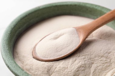 Beyaz arka planda bir kase agar pudrası, yakın plan.