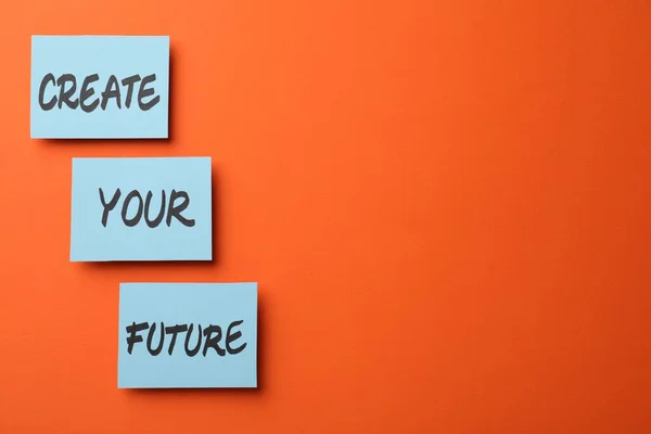 Motivational phrase Create Your Future made of sticky notes with words on orange background. Space for text