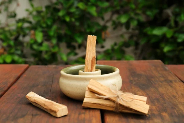 Palo Santo (holy wood) sticks and holder on wooden table outdoors