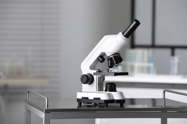 Modern medical microscope on metal table in laboratory, space for text