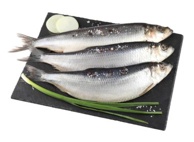 Beyaz renkte tuzlanmış ringa balığı, baharat ve soğan tabağı.