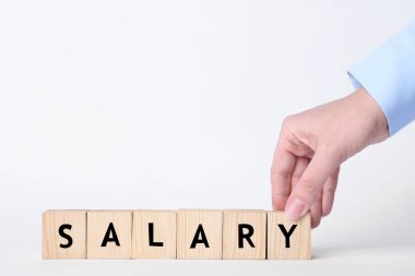 Beyaz arka planda tahta küplerle kelime aylığı yapan kadın, yakın plan