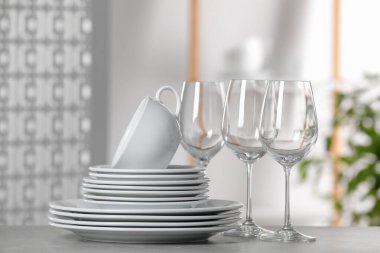 Açık gri masada temiz bulaşık takımı ve bardaklar.