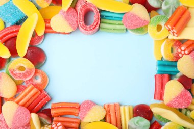 Açık mavi arka planda birçok farklı jöle şekeri çerçevesi, düz yatıyordu. Metin için boşluk