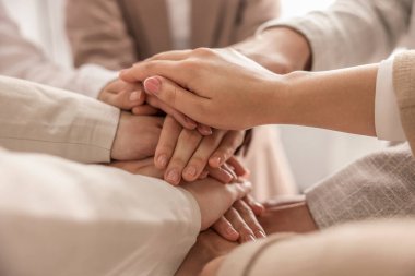 Group of people holding hands together indoors, closeup. Unity concept