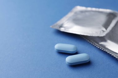 Mavi arka planda haplar ve prezervatifler, mesaj için yer. İktidar sorunu