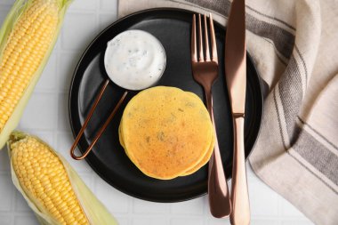 Beyaz fayanslı masada servis edilen soslu lezzetli mısır krepleri.