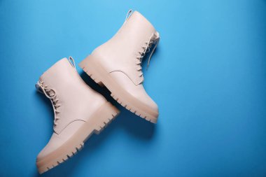 Açık mavi arka planda bir çift şık deri ayakkabı, düz. Metin için boşluk