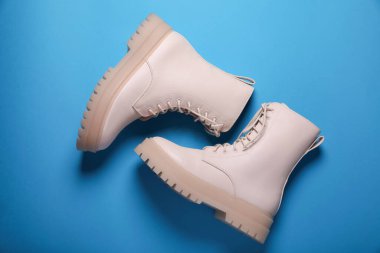 Açık mavi arka planda bir çift şık deri ayakkabı.