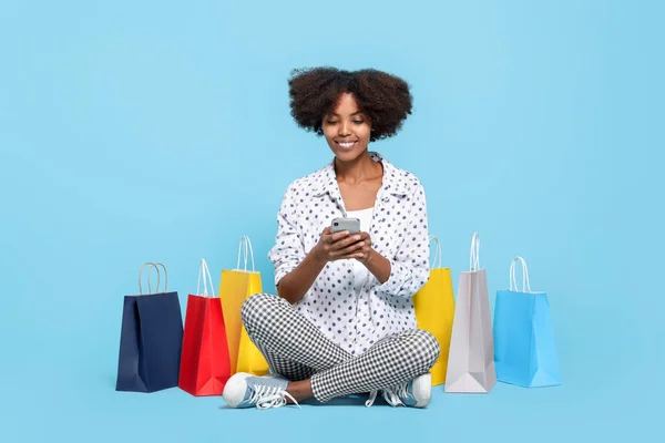 Donna Afroamericana Felice Con Borse Della Spesa Smartphone Sfondo Azzurro — Foto Stock
