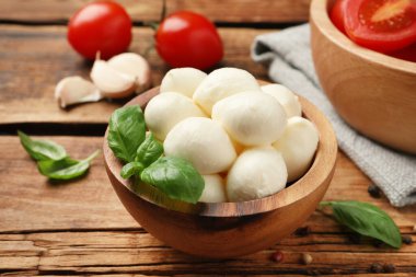 Nefis mozzarella topları ve fesleğen yaprakları ahşap masada, yakın plan.