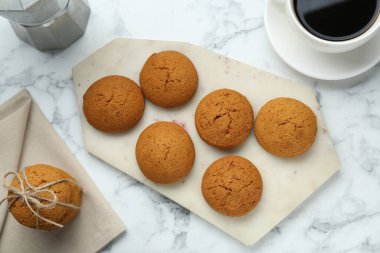 Lezzetli yulaflı kurabiyeler ve beyaz mermer masada bir fincan kahve.