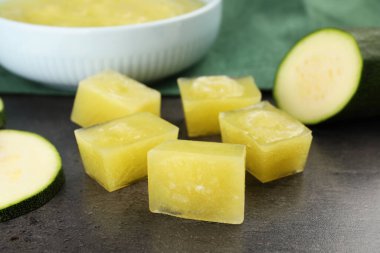 Donmuş kabak püresi küpleri ve gri masada taze kabak, yakın plan.