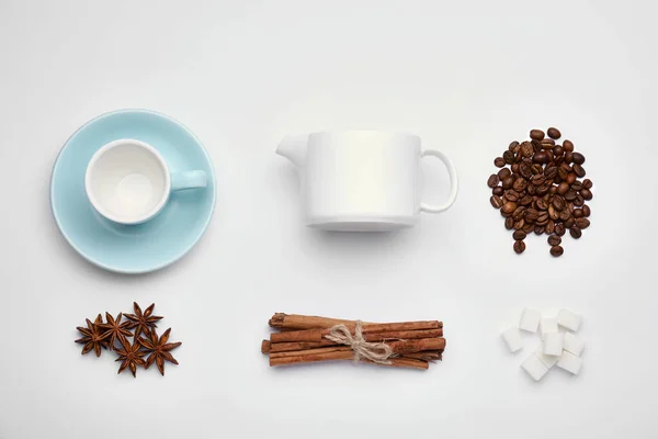 Flat lay composition with roasted coffee beans and spices on white background
