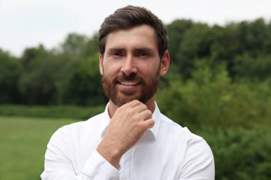 Parktaki yakışıklı sakallı adamın portresi.