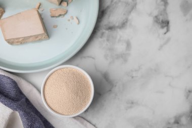 Granüle edilmiş ve sıkıştırılmış maya beyaz mermer masada, düz yerde. Metin için boşluk