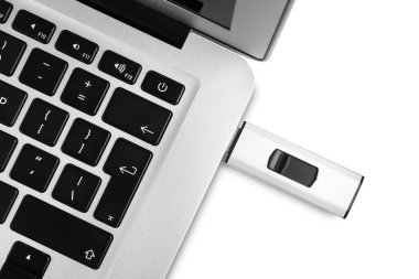 Üst görünümde, beyaz arkaplanda dizüstü bilgisayara eklenmiş modern usb flash diski