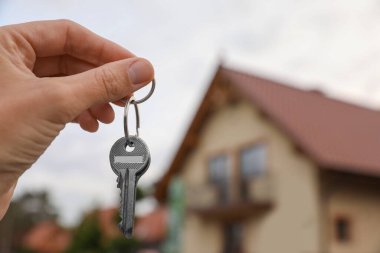 Yeni evin anahtarlarını elinde tutan emlakçı, yakın plan. Metin için boşluk